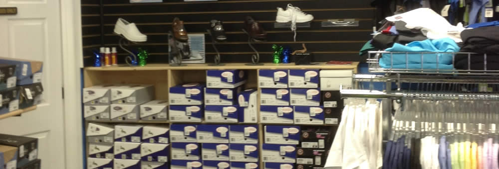 Display of medical shoes and clogs with stacked shoe boxes at Simply Uniforms