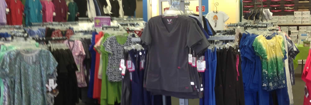 Racks of scrub tops in a range of colours and prints inside the Simply Uniforms store
