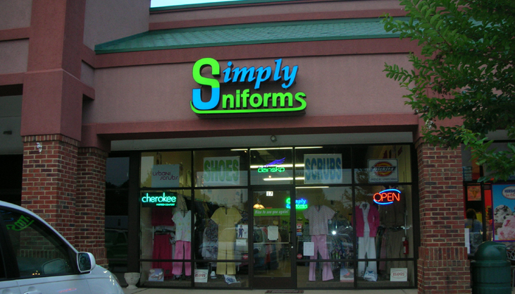 The Simply Uniforms shopfront at 2785-26 Charlotte Highway, Mooresville NC, lit at dusk